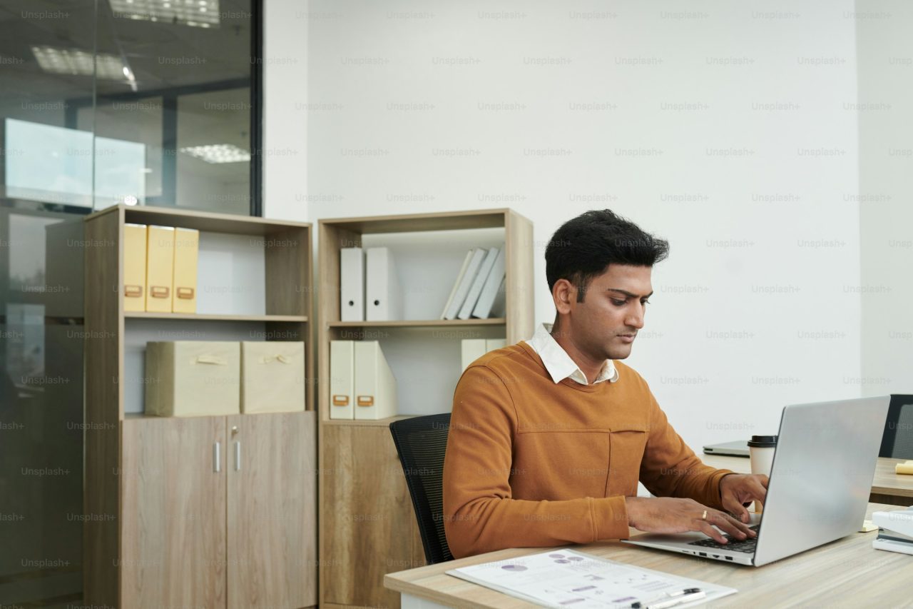Payroll specialist reviewing workforce data on a laptop